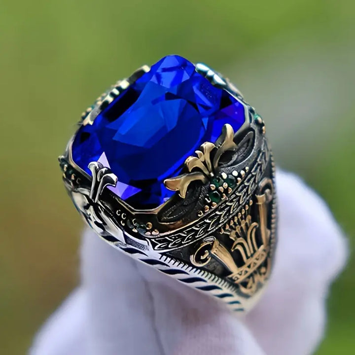 Anel vintage de prata com safira azul, design clássico, da marca Rose & Oliver, detalhado com pedra central brilhante.