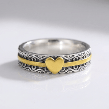 Anillo de banda en oro hecho a mano con corazón, de la marca Rose & Oliver, mostrado en primer plano en la imagen.