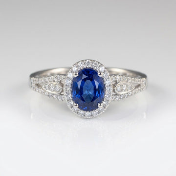 Vintage-Ring Rose & Oliver mit blauem Saphir-Halo und Silberdetails, Hervorhebung für das elegante Design und den strahlenden zentralen Stein.